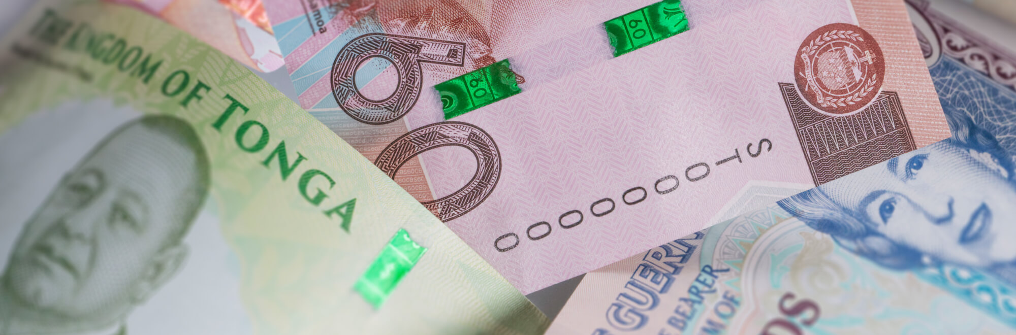 a collection of multi-coloured bank notes from all around the world