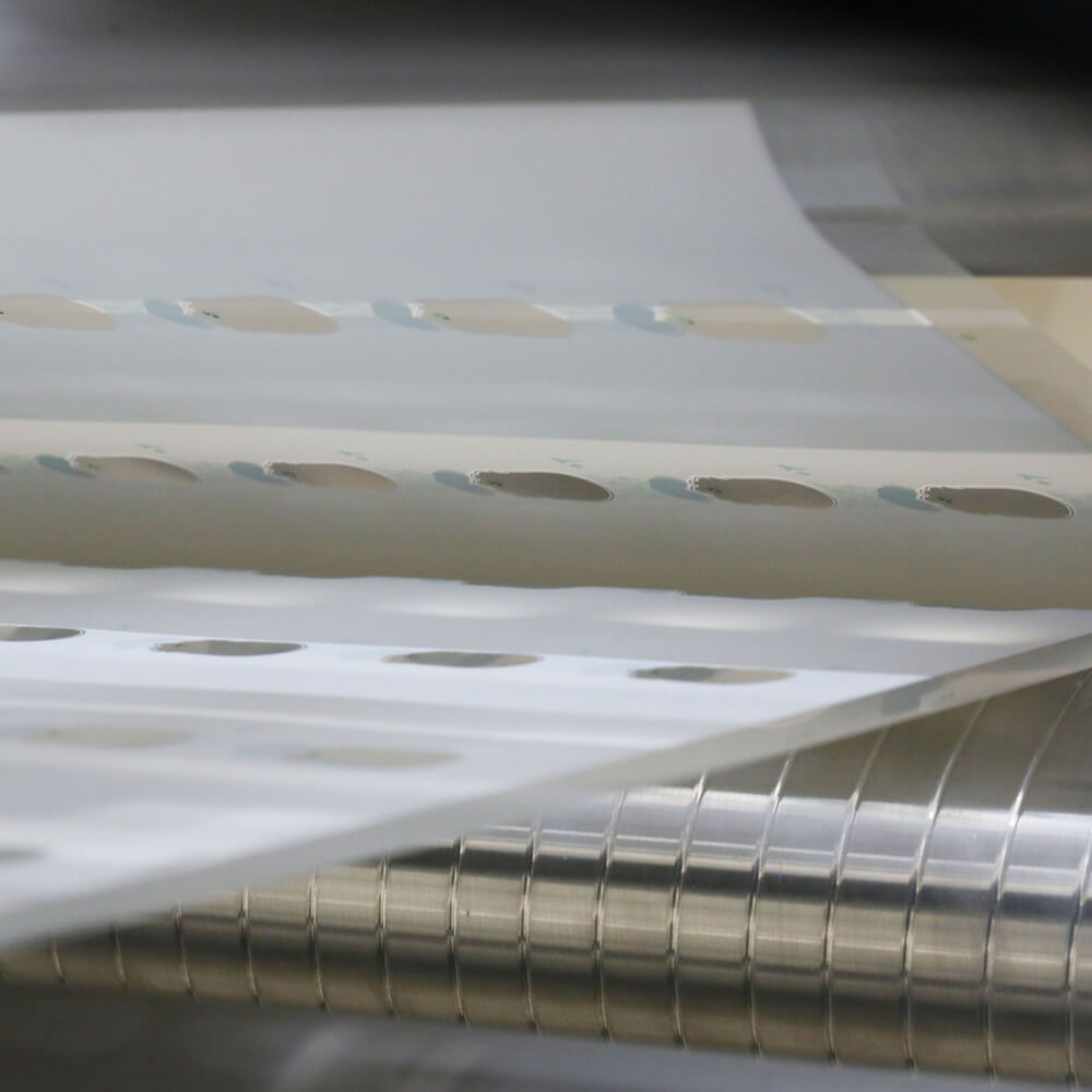 a sheet of holograms being processed by an industrial printer