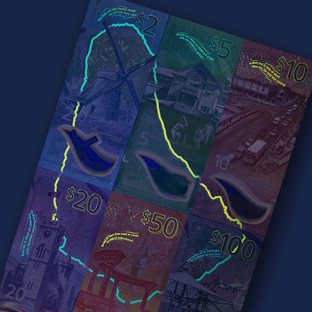 a selection of Barbadian bank notes being illuminated under UV light in a dark room