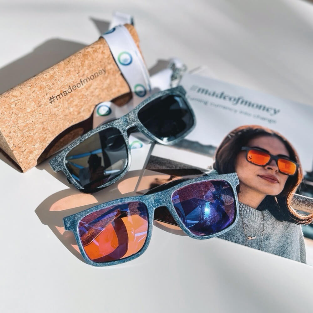 a collection of sunglasses and cork-made glasses case sit on top of a brochure